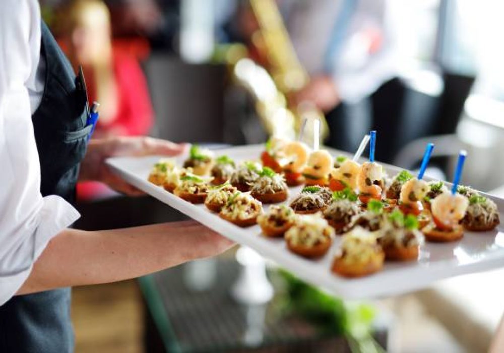Waiter carrying plates with meat dish on some festive event, party or wedding reception
