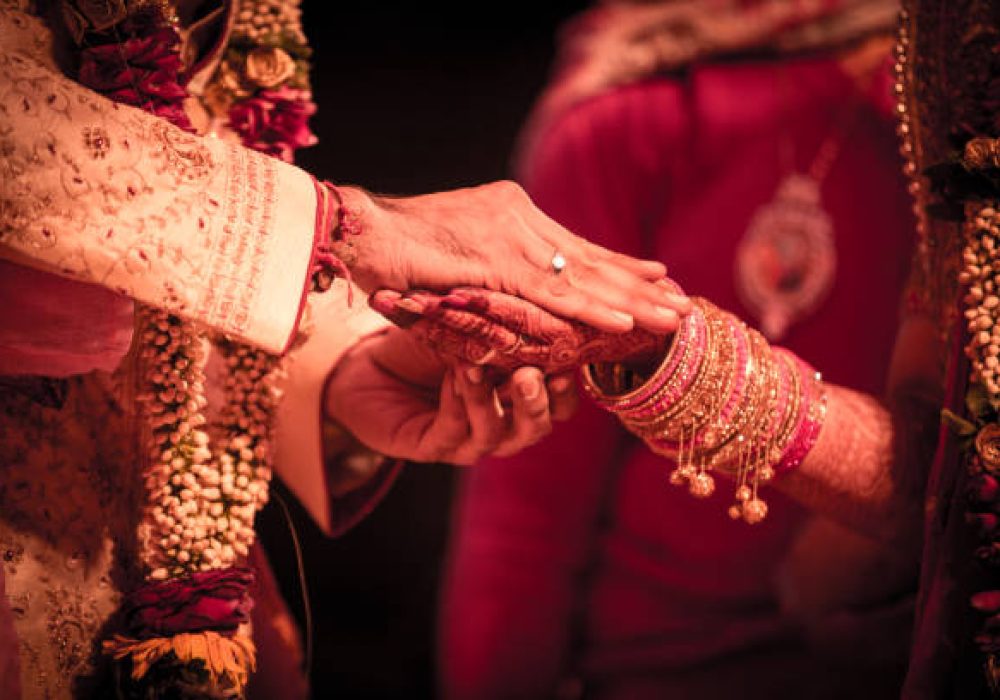 Closeup of indian wedding couple holding hands.
